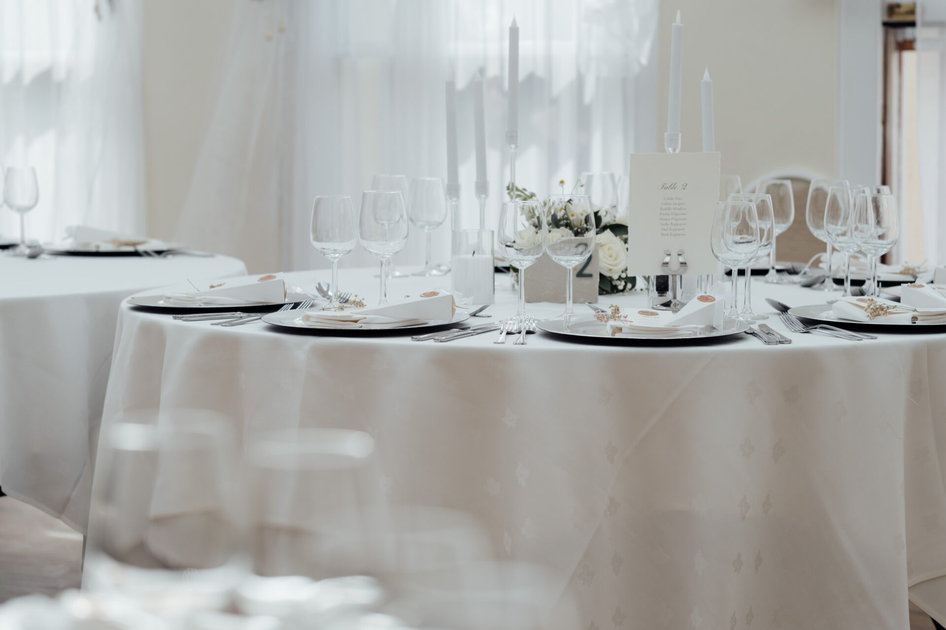 A round table with a white tablecloth and candles.