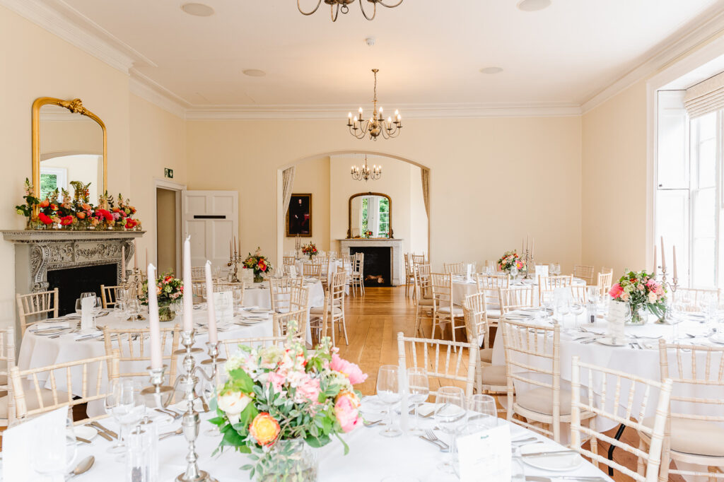 A large wedding reception room with archways and set tables.