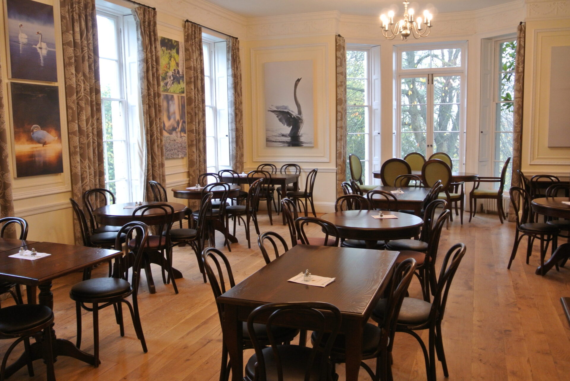 A grand dining room with wooden tables and chairs.