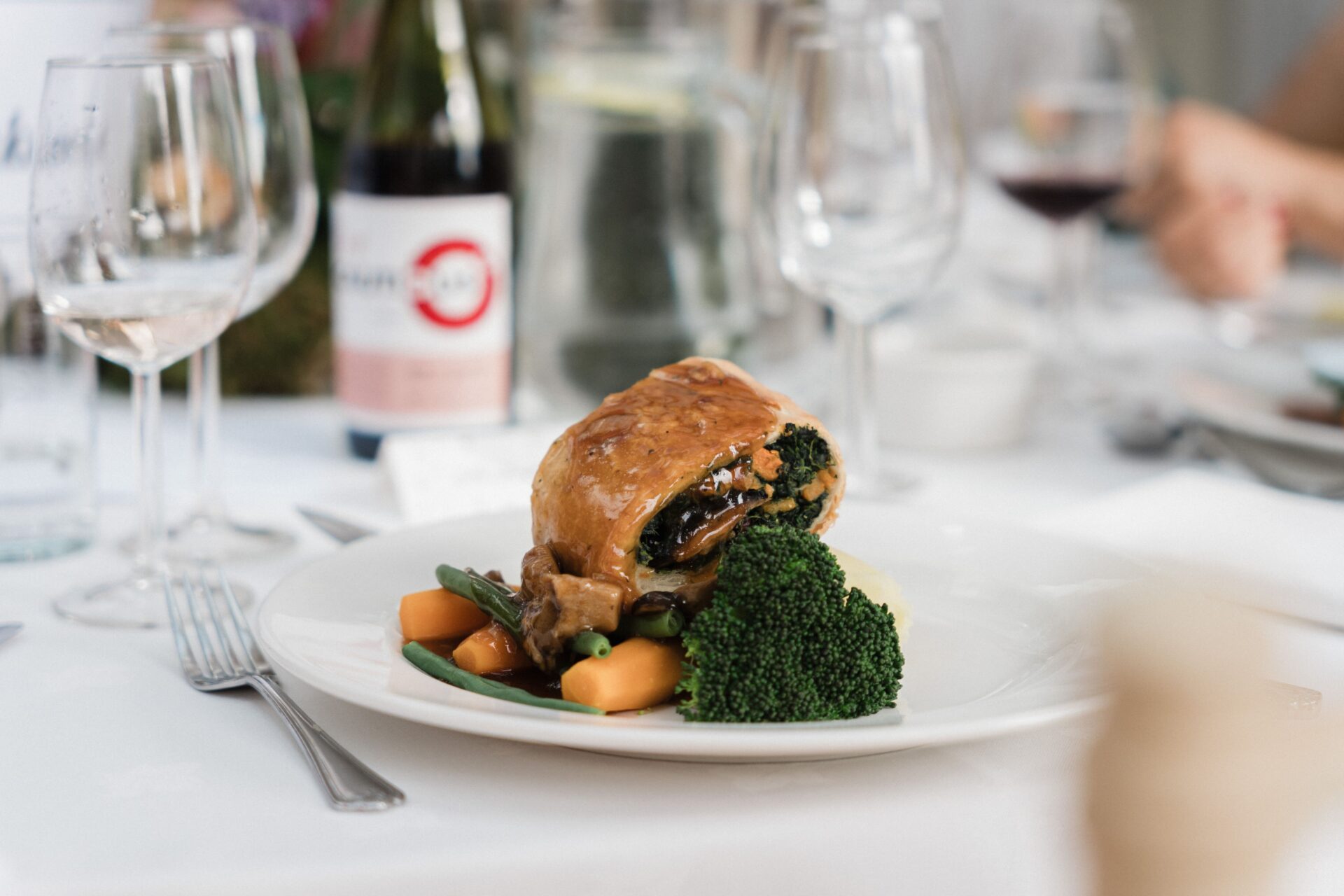 A close up of a pastry dish with vegetables and sauce.