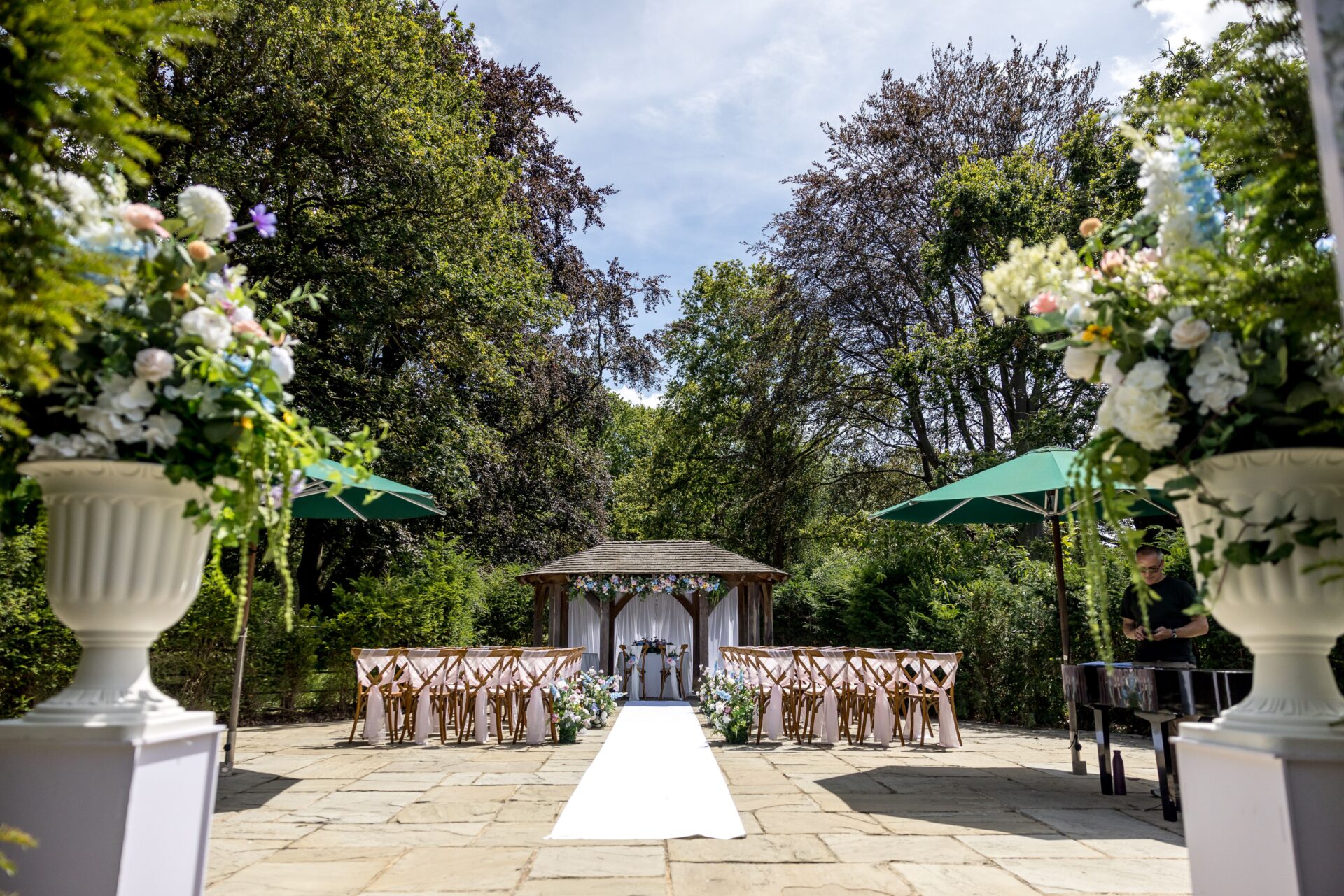 A grand gardne patio area with rows of chairs and a white long carpet.