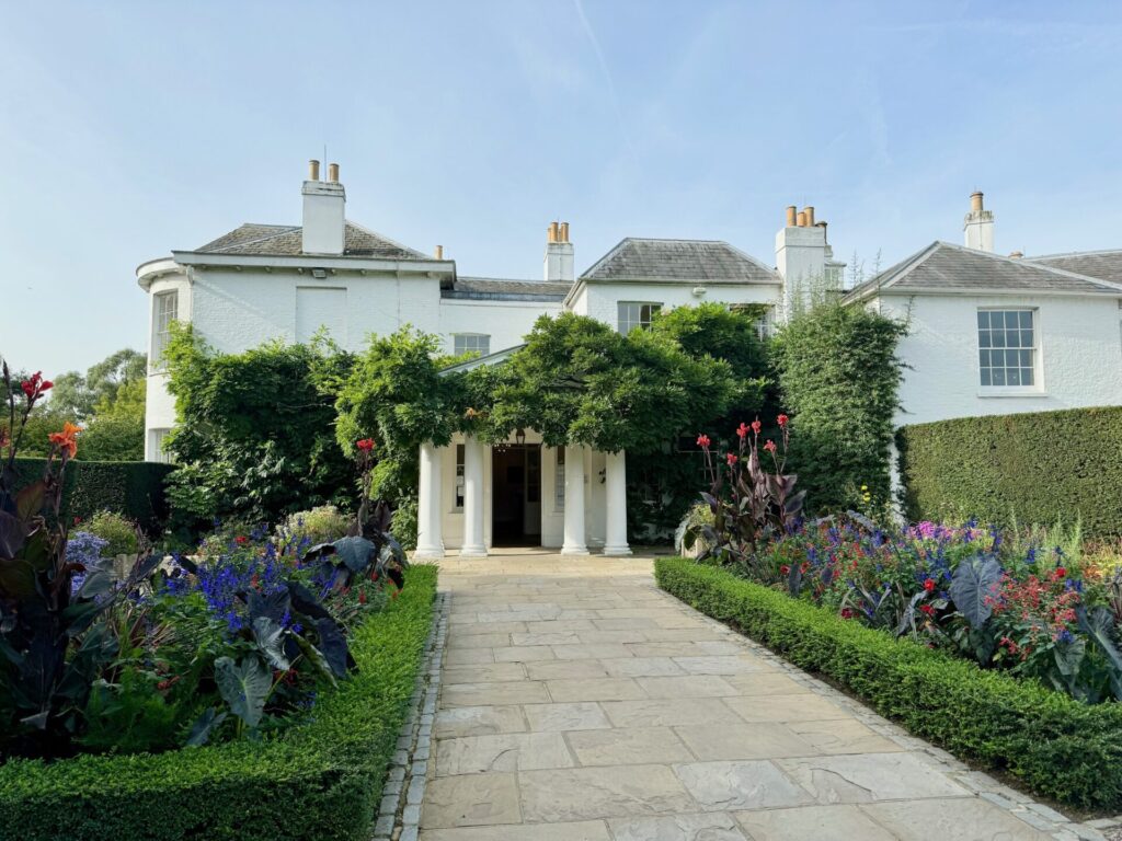 An ornate white Georgian building with Wisteria.